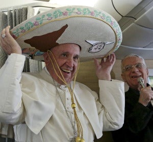 El Papa Francisco recibe un sombrero mexicano de parte de un periodista durante el vuelo