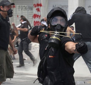 Manifestante griego con máscara de gas