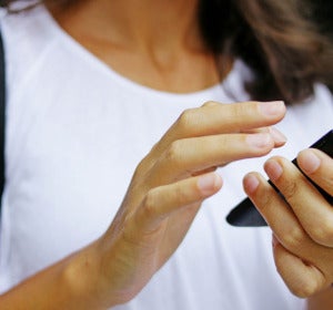 Una usuaria con su teléfono móvil Una usuaria con su teléfono móvil