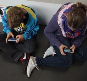 Niños consultando el móvil