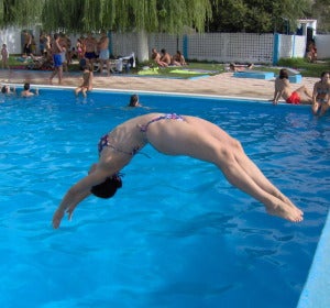 Una mujer se tira de espaldas a una piscina