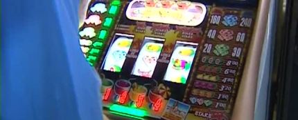 Una personas juega a una máquina tragaperras. Una personas juega a una máquina tragaperras.
