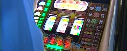 Una personas juega a una máquina tragaperras. Una personas juega a una máquina tragaperras.