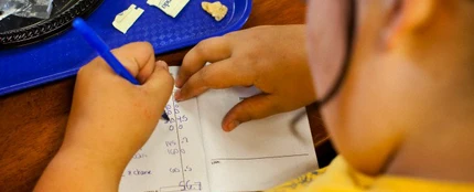 Niño haciendo los deberes después de comer Niño haciendo los deberes después de comer