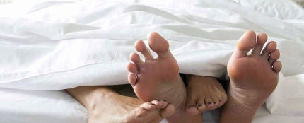 Pies de una pareja en una cama