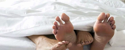Pies de una pareja en una cama Pies de una pareja en una cama