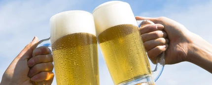 Dos personas brindan con cerveza Dos personas brindan con cerveza