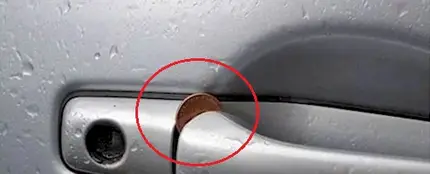 Moneda en la maneta de un coche Moneda en la maneta de un coche
