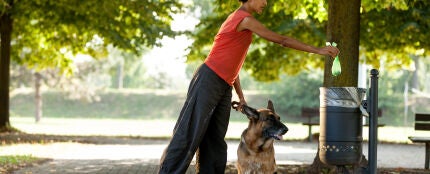 Mujer recogiendo las cacas de su perro