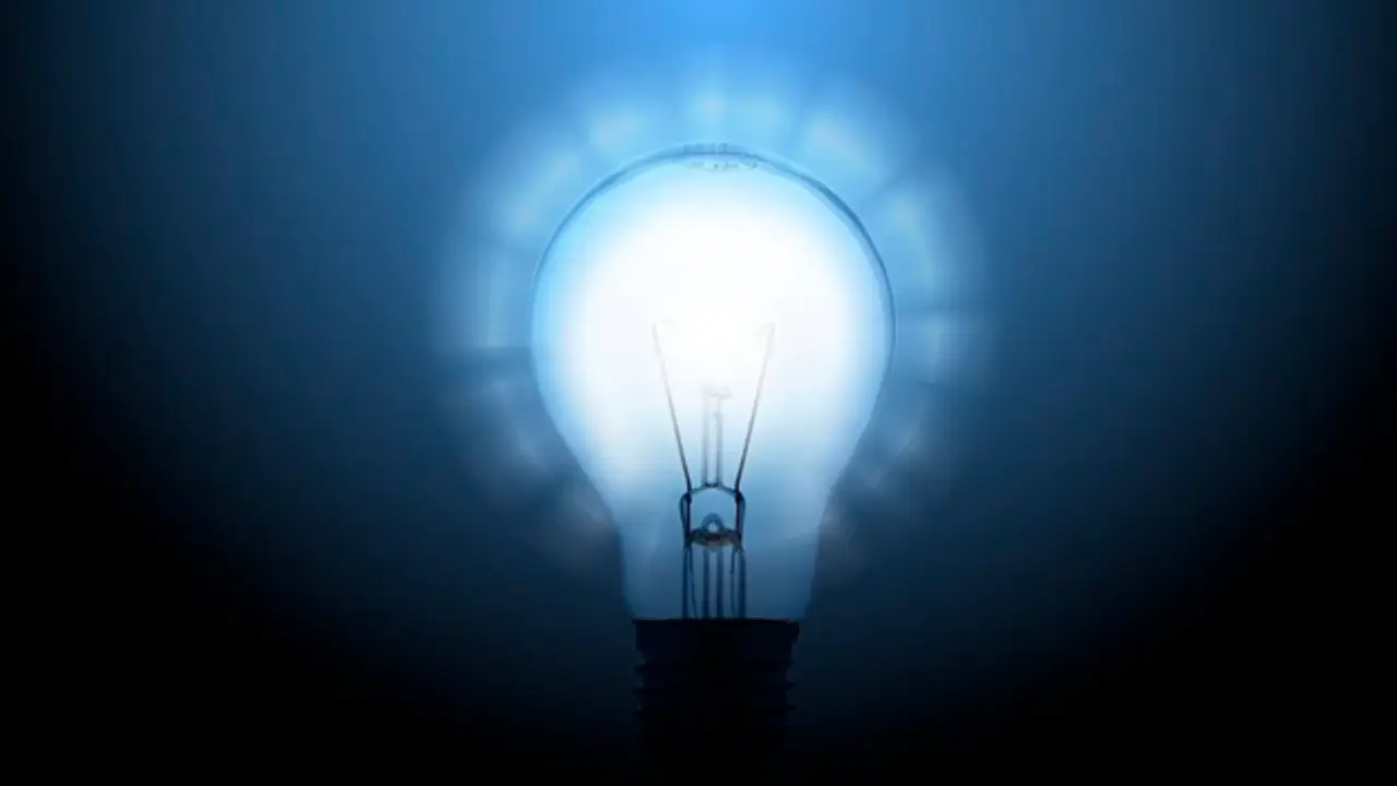 Imagen de una bombilla sobre fondo azul Imagen de una bombilla sobre fondo azul