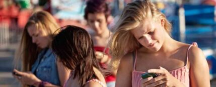Un grupo de chicas consulta su tel&eacute;fono m&oacute;vil