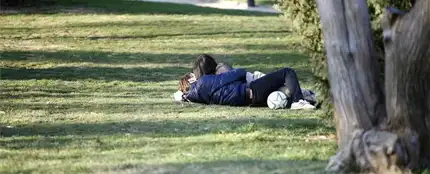 Pareja besándose en un parque Pareja besándose en un parque