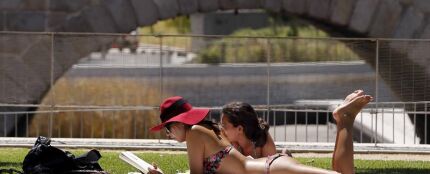 Dos personas toman el sol en las inmediaciones del parque de Madrid Río Dos personas toman el sol en las inmediaciones del parque de Madrid Río
