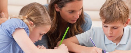 Una madre ayudando a sus hijos con los deberes
