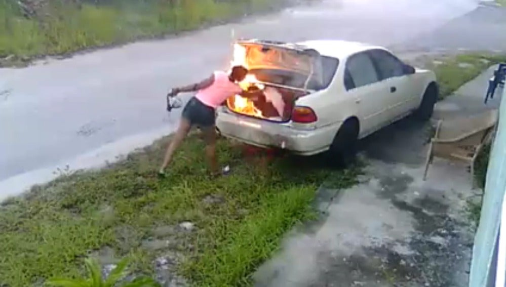 Imagen de la joven quemando el coche.