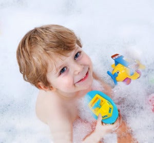 Un niño jugando en la bañera Un niño jugando en la bañera