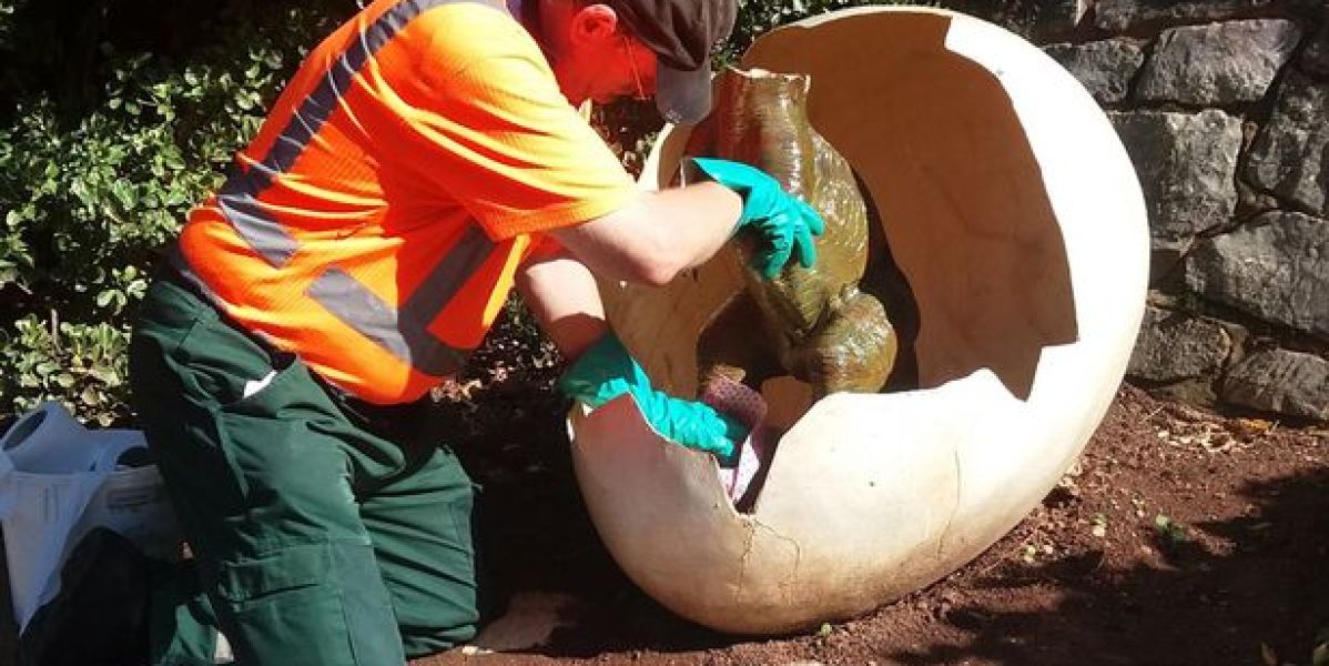 Labores de limpieza de la estatua del dinosaurio