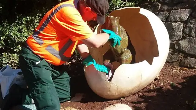 Labores de limpieza de la estatua del dinosaurio