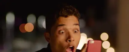 Joven asombrado mirando un mensaje de WhatsApp Joven asombrado mirando un mensaje de WhatsApp