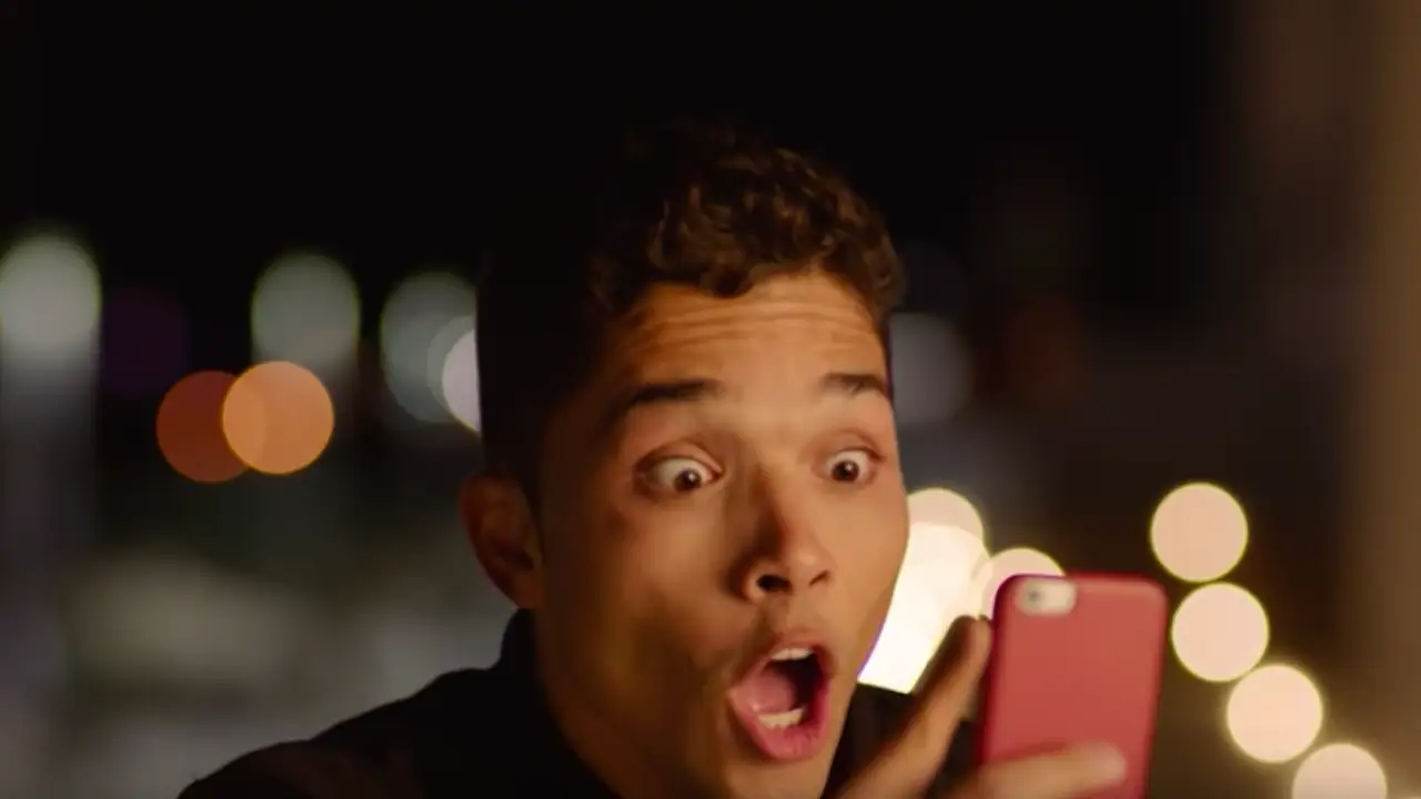 Joven asombrado mirando un mensaje de WhatsApp Joven asombrado mirando un mensaje de WhatsApp