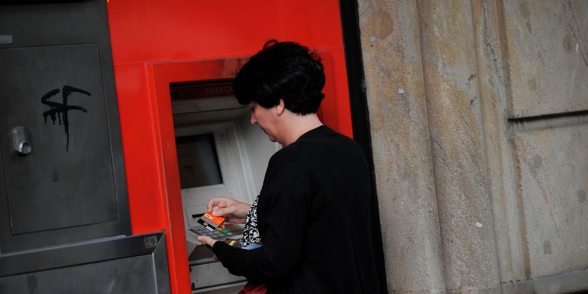 Una mujer saca dinero de un cajero automático