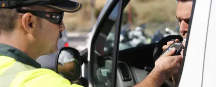 Un agente realiza una prueba de alcoholemia Un agente realiza una prueba de alcoholemia