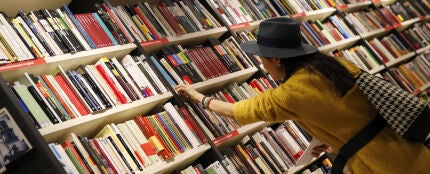 Una mujer mira libros en los estanterías de una librería