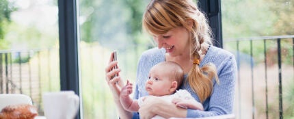 Una madre con su bebé mirando un smartphone