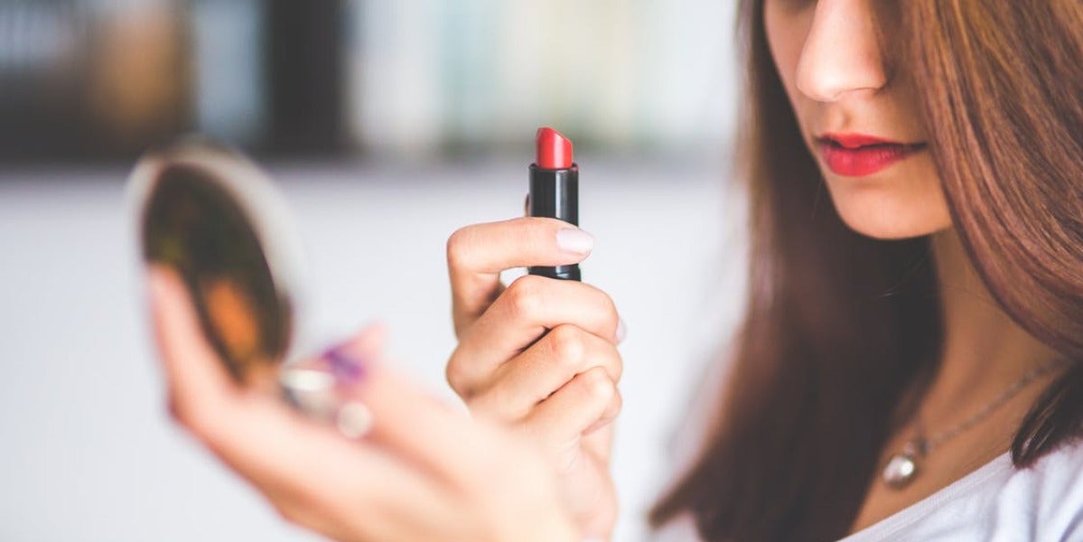 Una chica se pinta los labios