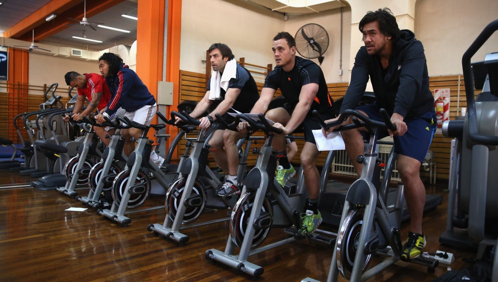 Personas usando la bicicleta estática