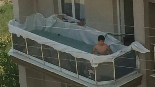 Piscina improvisada de un niño en el balcón de casa