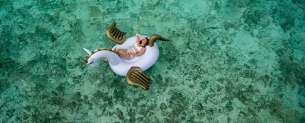 Una chica en un flotador de unicornio Una chica en un flotador de unicornio