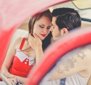 Una pareja se besa en el coche Una pareja se besa en el coche