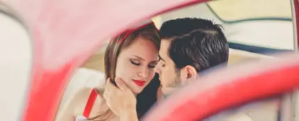 Una pareja se besa en el coche Una pareja se besa en el coche