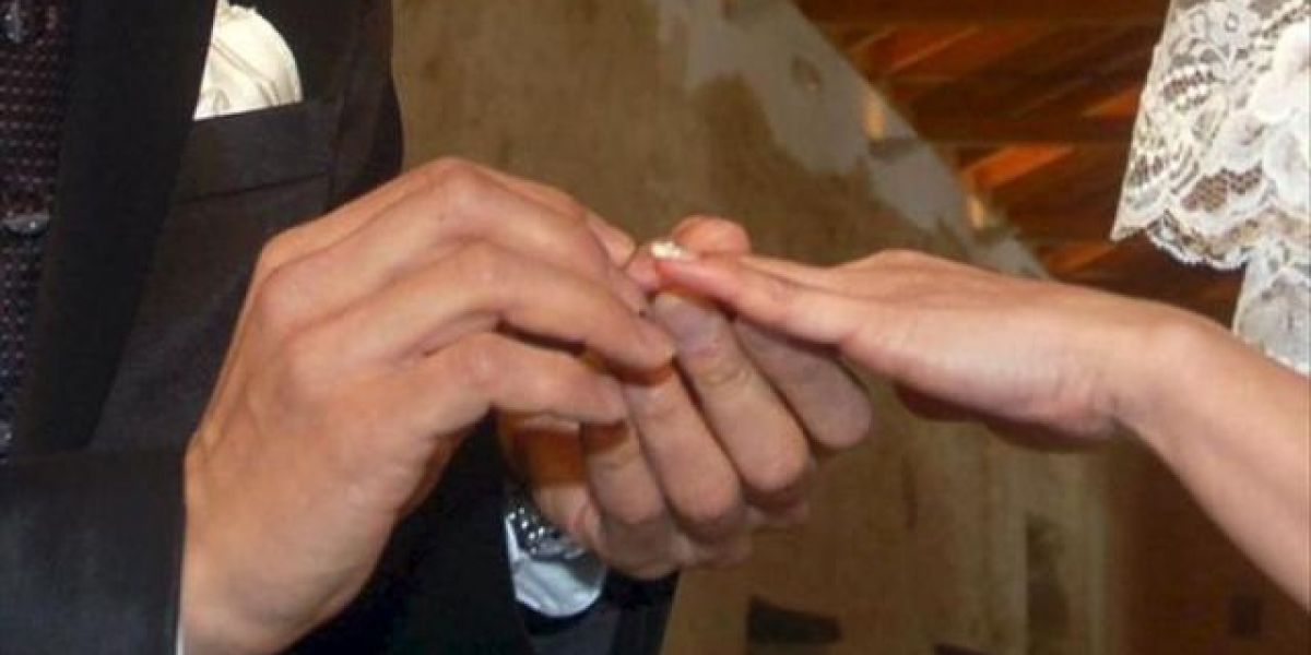Manos de una pareja intercambiando los anillos en la ceremonia de su boda