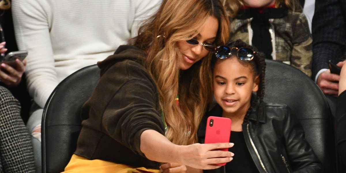 Beyoncé y Blue Ivy haciéndose un selfie durante un partido de la NBA