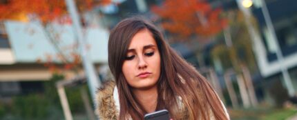 Una adolescente mira el móvil