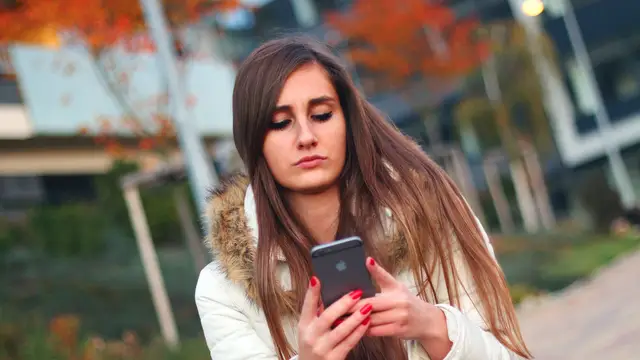 Una adolescente mira el móvil