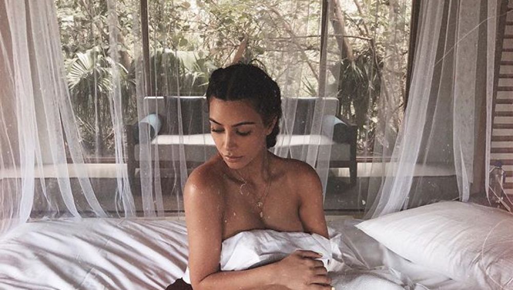 Kim Kardashian sentada en la cama