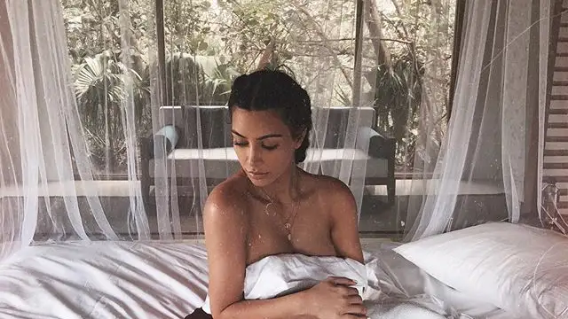 Kim Kardashian sentada en la cama