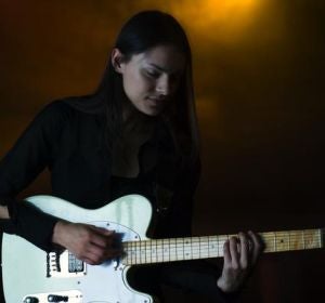 Una chica tocando la guitarra eléctrica en un pub Una chica tocando la guitarra eléctrica en un pub