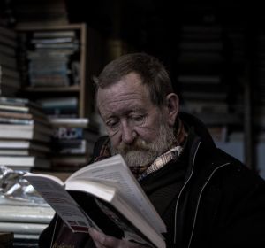 Un hombre leyendo en una biblioteca Un hombre leyendo en una biblioteca