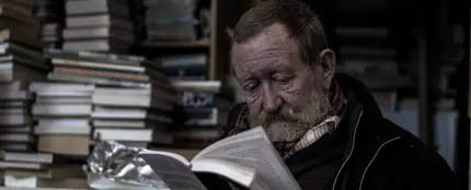 Un hombre leyendo en una biblioteca Un hombre leyendo en una biblioteca