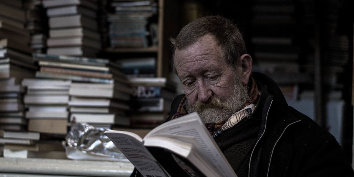 Un hombre leyendo en una biblioteca