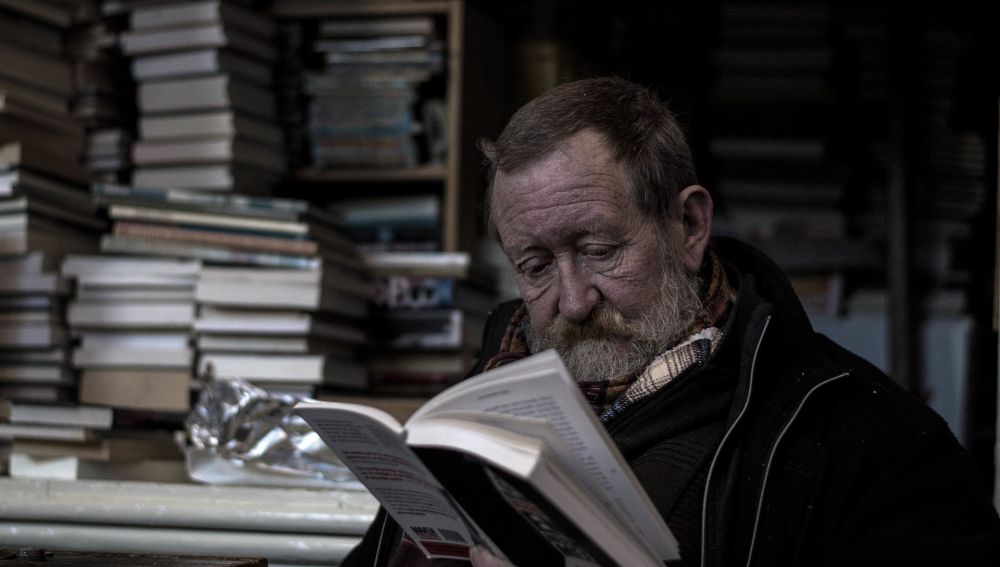 Un hombre leyendo en una biblioteca