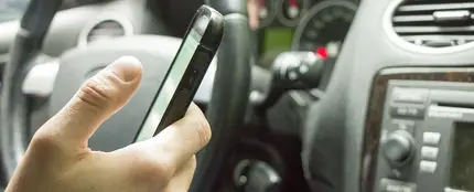 Imagen de archivo de un conductor usando el móvil al volante Imagen de archivo de un conductor usando el móvil al volante