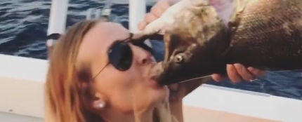 El extraño vídeo de una mujer bebiendo cerveza desde un pez muerto