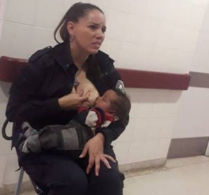 Imagen de una policía amamantando a un bebé Imagen de una policía amamantando a un bebé