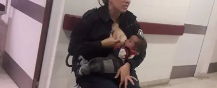 Imagen de una policía amamantando a un bebé Imagen de una policía amamantando a un bebé