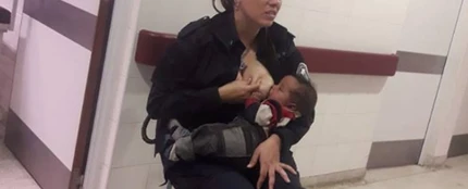 Imagen de una policía amamantando a un bebé Imagen de una policía amamantando a un bebé